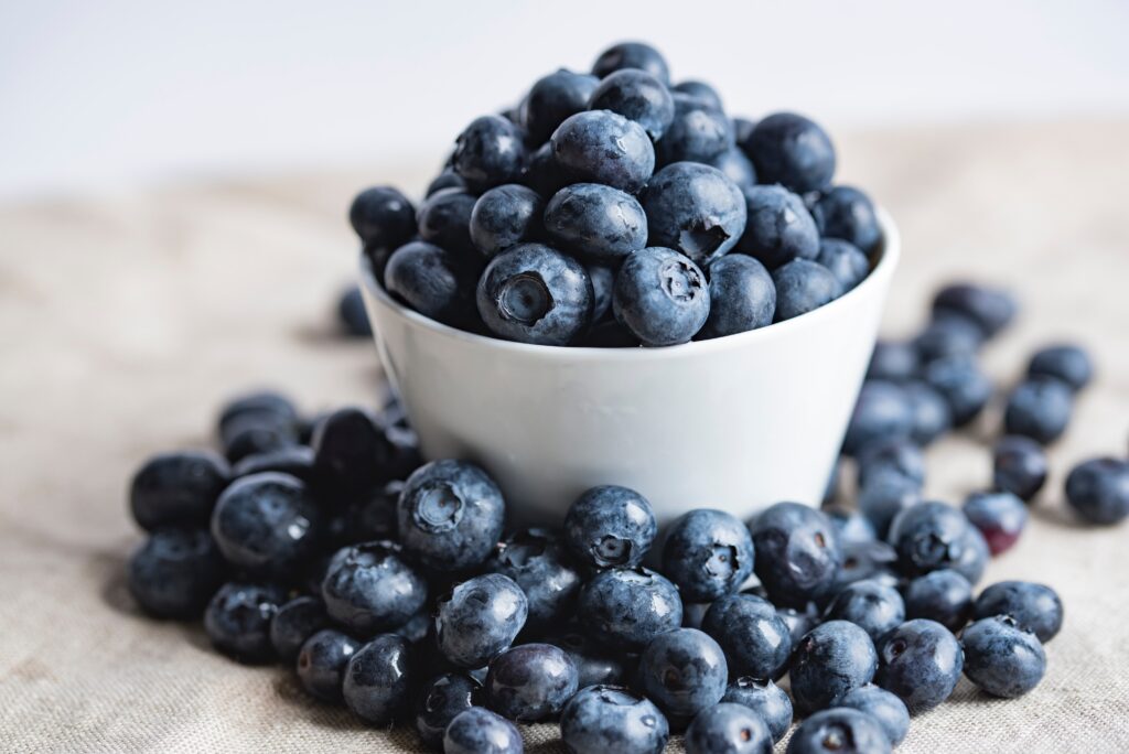 A bowl full of blueberries amidst the pile of blueberries